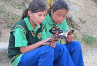Young women learn their rights from What Are Human Rights? The human rights booklet published by Youth for Human Rights International.