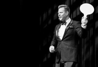 Jeffrey Manning holding a bidder paddle in live auction 