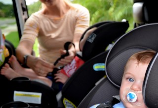 Nanny loading children into car seats